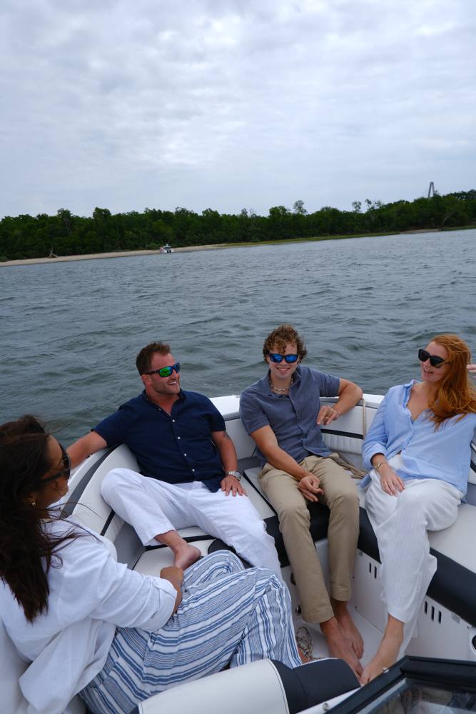 Four friends on a boat on the water, all wearing Rheos sunglasses